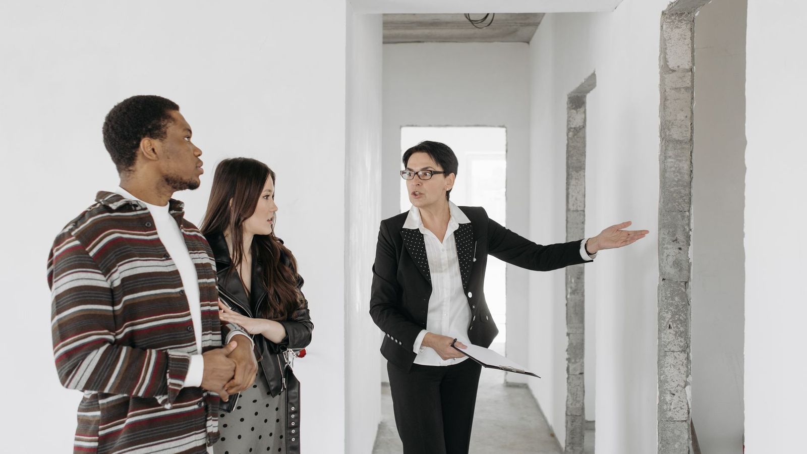 Un agent immobilier avec des clients dans un logement